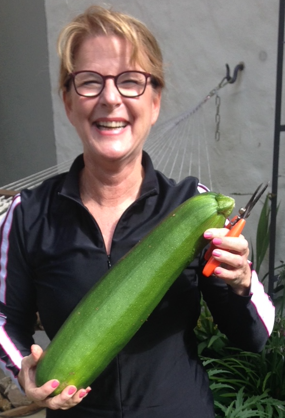 Trudi Schifter, co-founder of Yew Ventures AG, in the garden with a homegrown zucchini